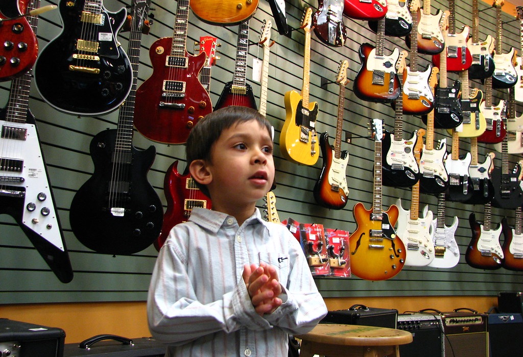 kids inside a guitar store choosing an instrument