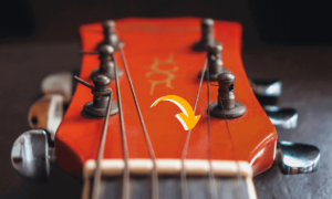 strings breaking behind guitar nut