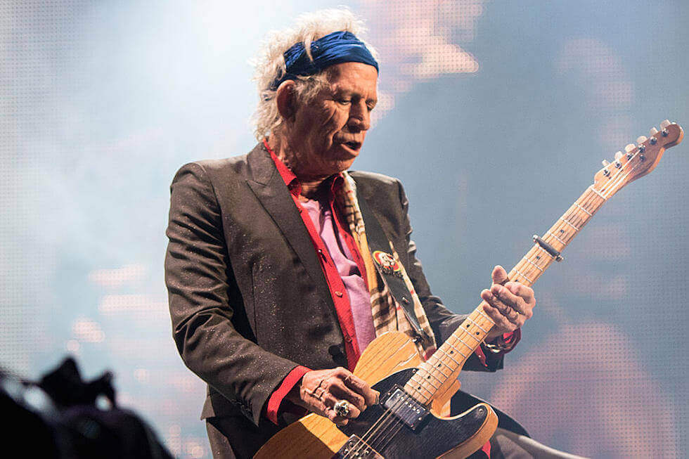 Keith Richards playing guitar on stage