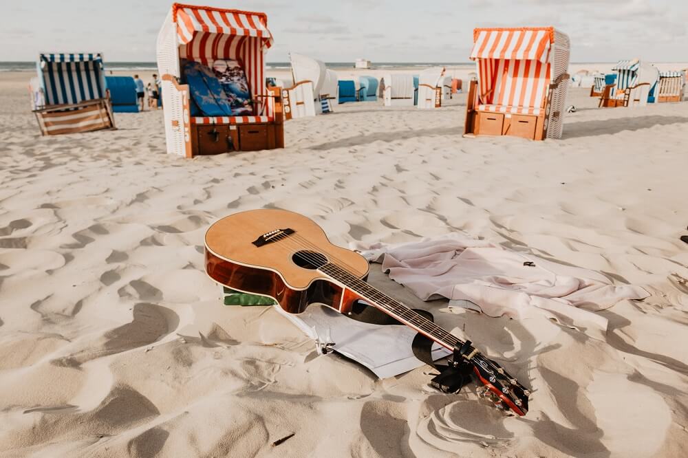 guitar sitting outside in the sand
