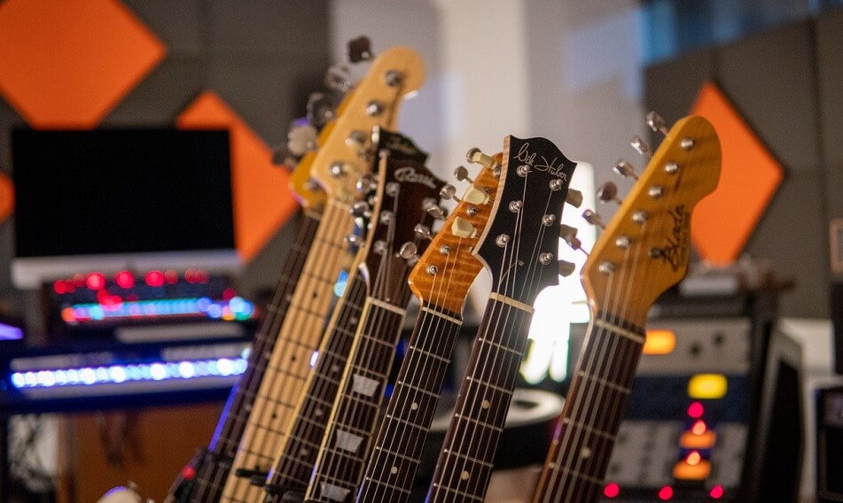 guitars side by side in guitar stand