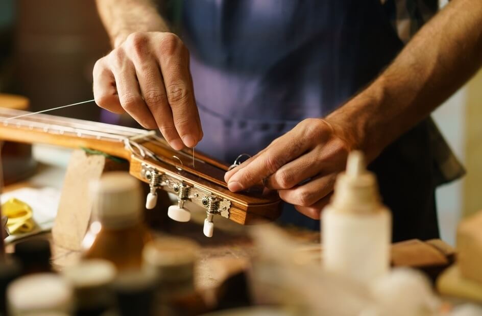 broken classical guitar string and someone changing it